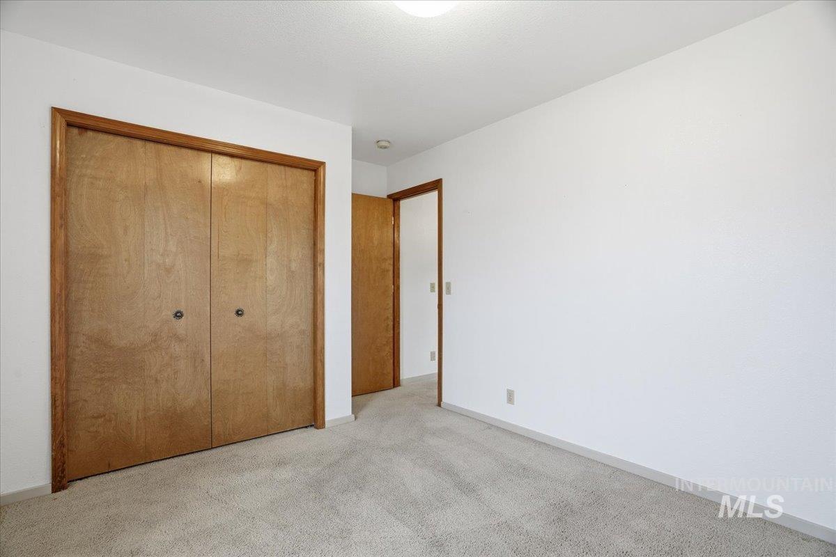 Unfurnished bedroom with carpet and a closet