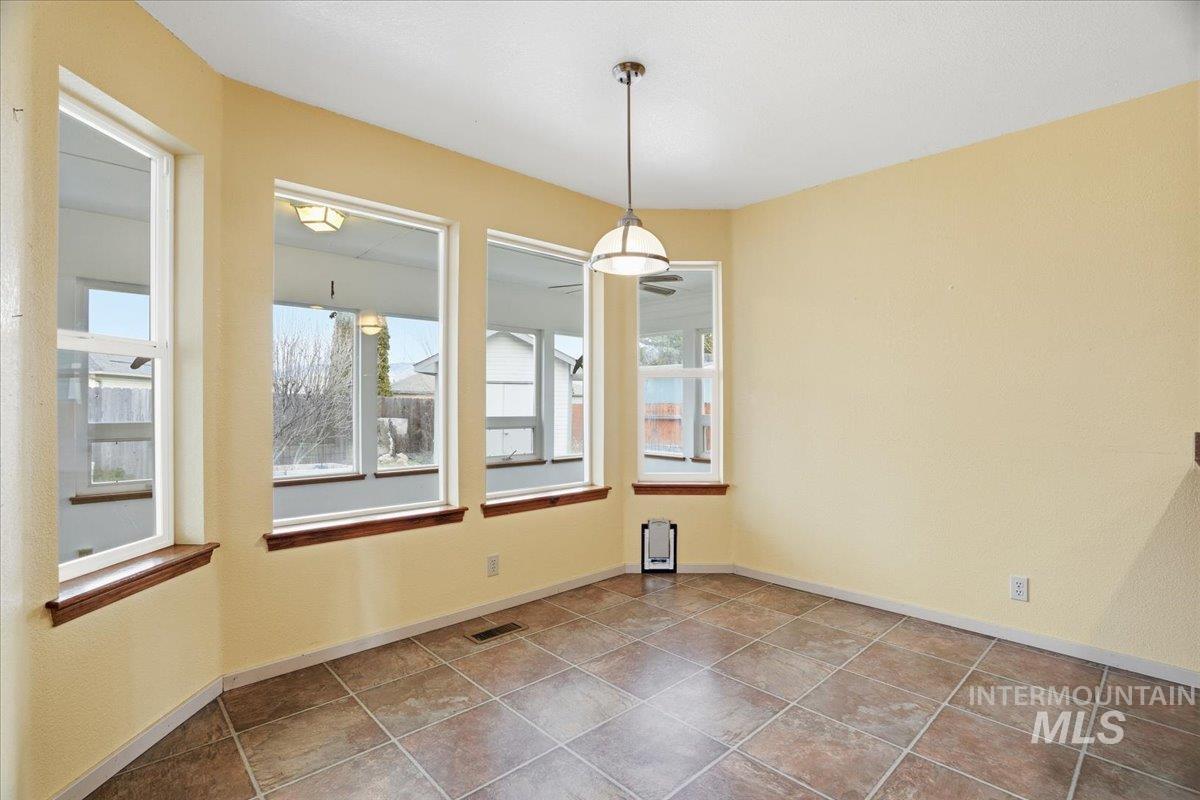 Unfurnished dining area featuring baseboards and tile patterned flooring