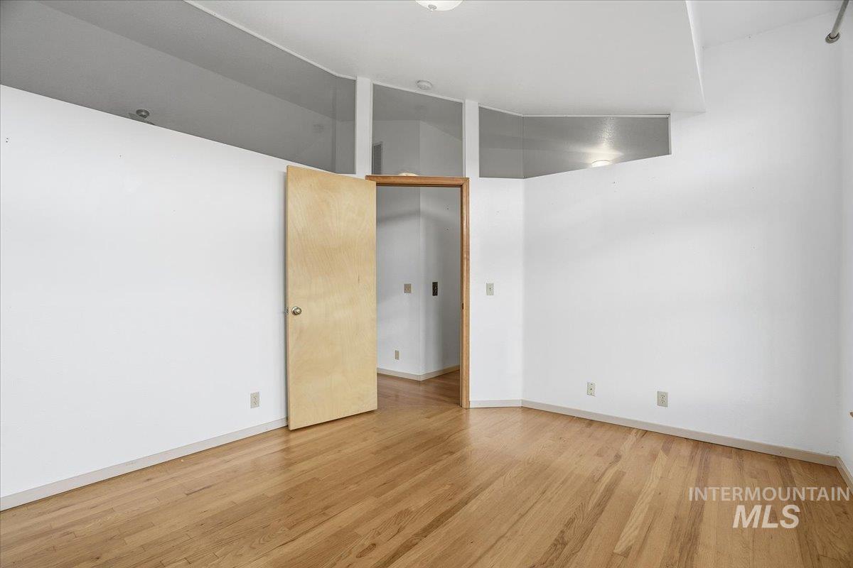 Spare room featuring light wood-type flooring and baseboards