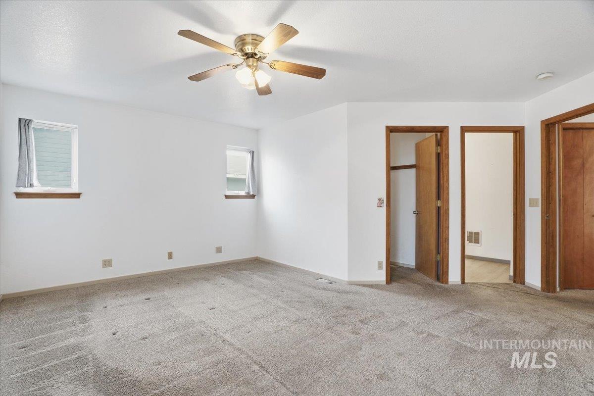 Unfurnished bedroom with light carpet, ceiling fan, and a closet