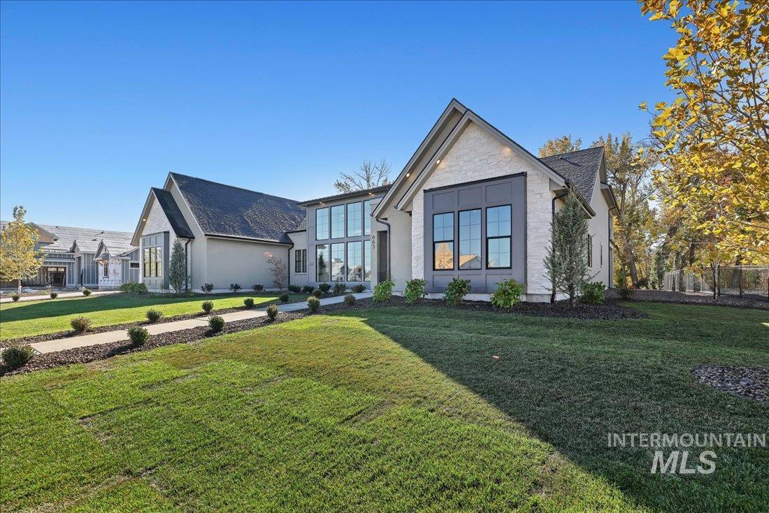 View of front of property featuring stone siding and a front yard