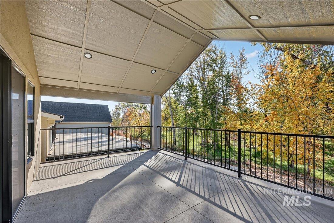 Wooden terrace featuring a patio area and view of wooded area