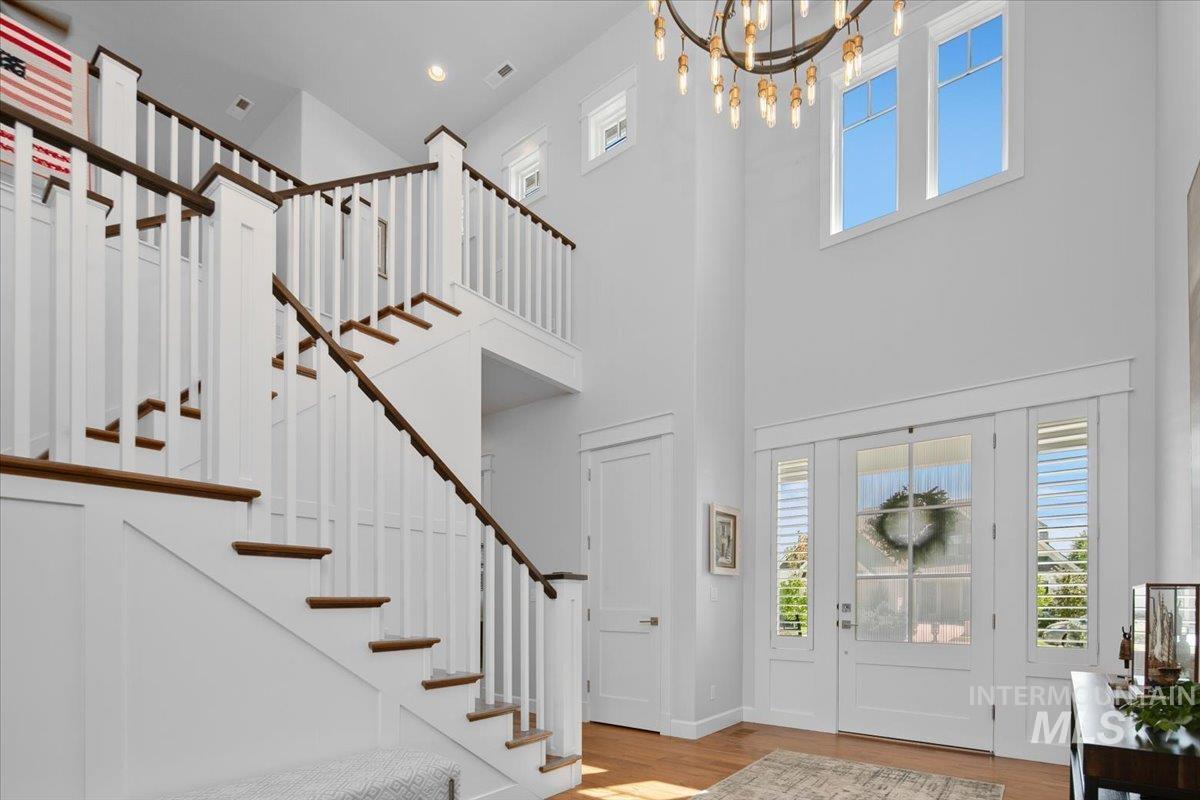Entryway with plenty of natural light, wood finished floors, and stairs