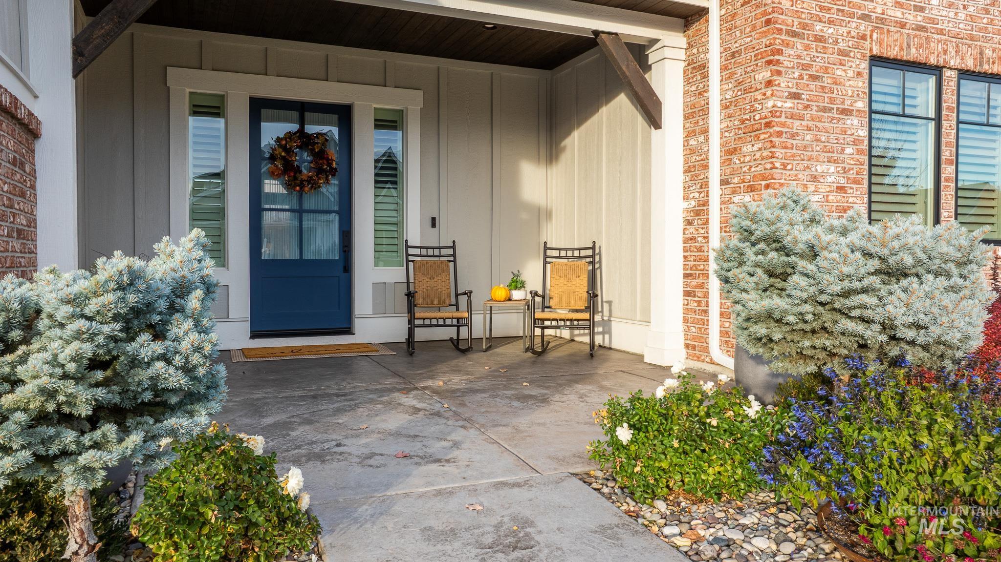 Doorway to property featuring a porch, board and batten siding, and brick siding