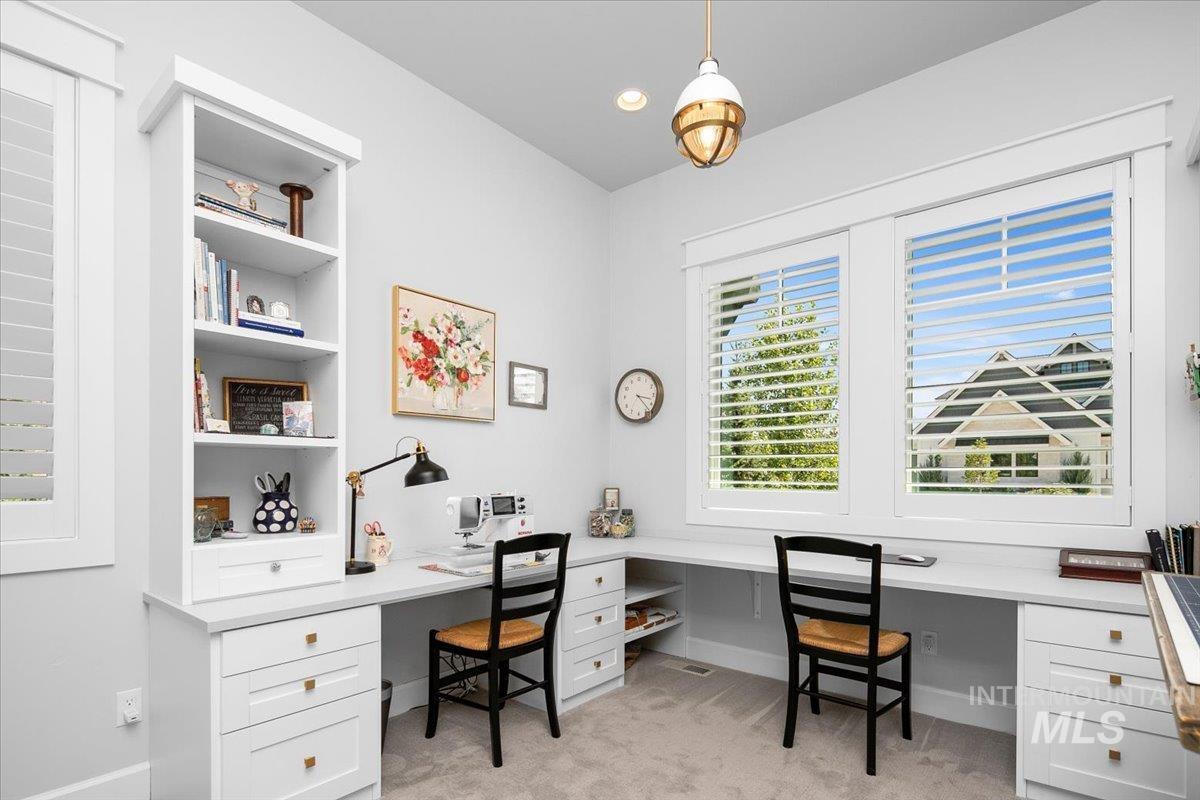 Bedroom with built in study area and light colored carpet