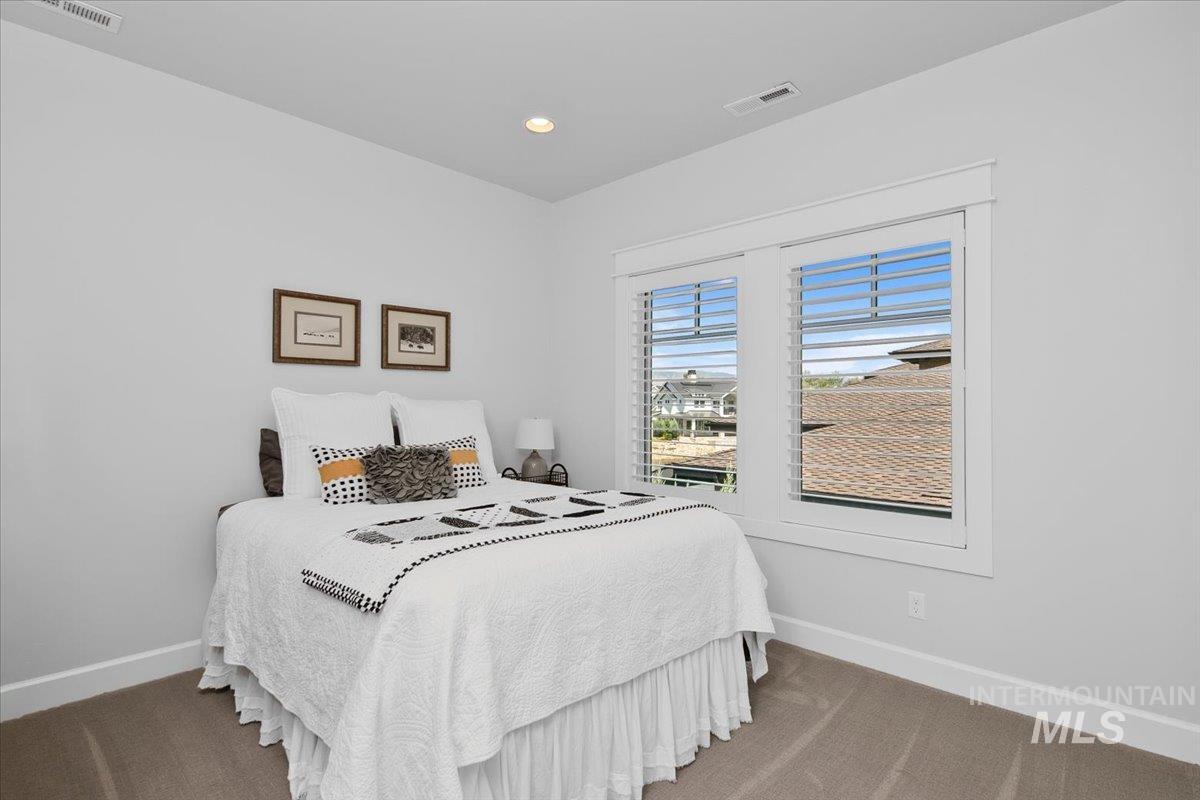 Carpeted bedroom with baseboards and recessed lighting