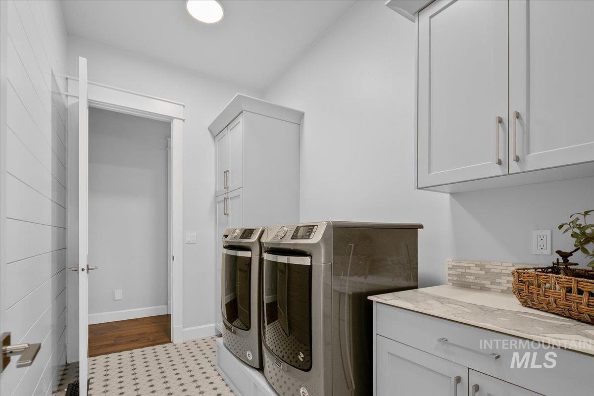 Washroom featuring cabinet space and washer and dryer