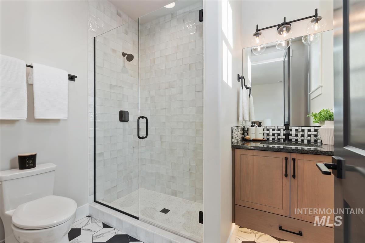 Full bath featuring vanity and a shower stall