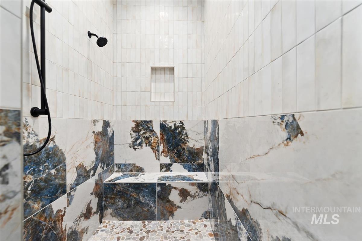 Full bath with a marble finish shower