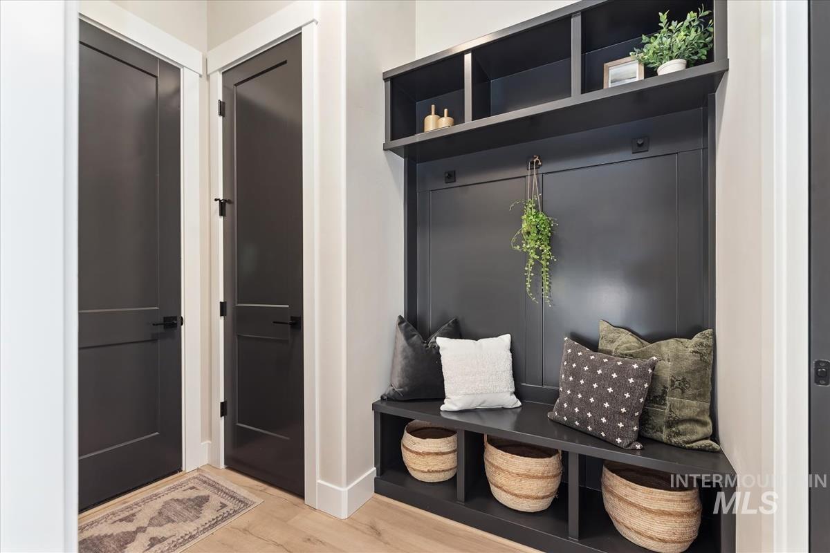 Mudroom featuring light wood-style flooring and baseboards