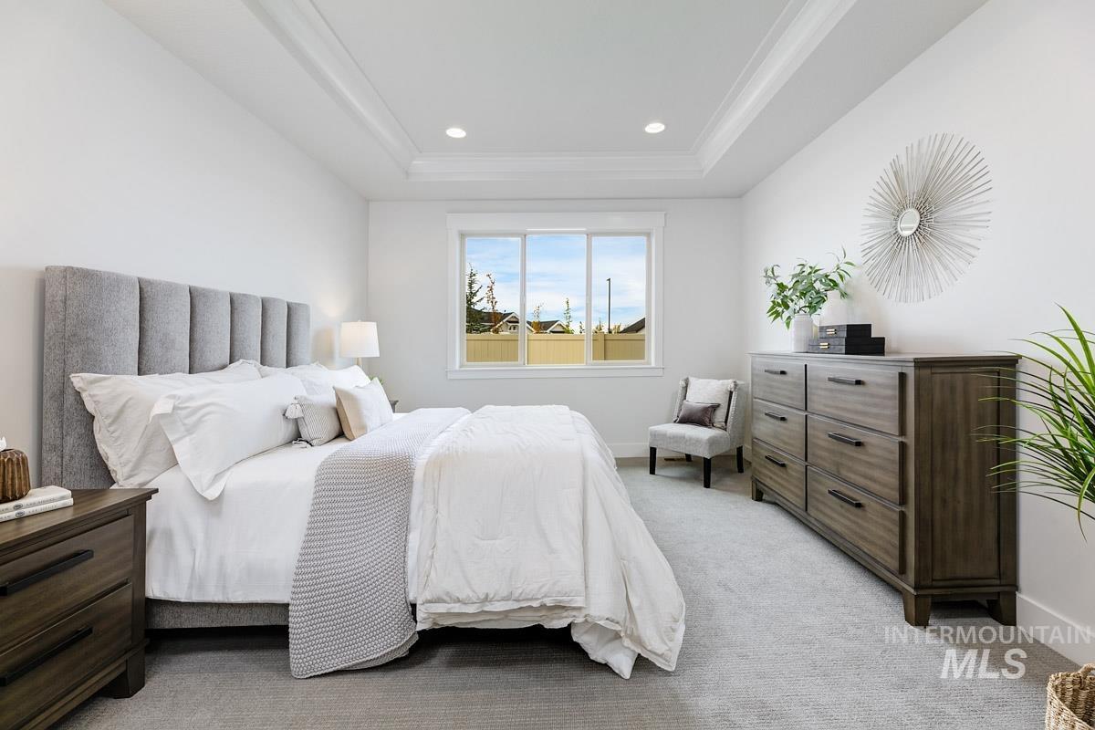 Bedroom with light colored carpet, recessed lighting, a tray ceiling, and ornamental molding