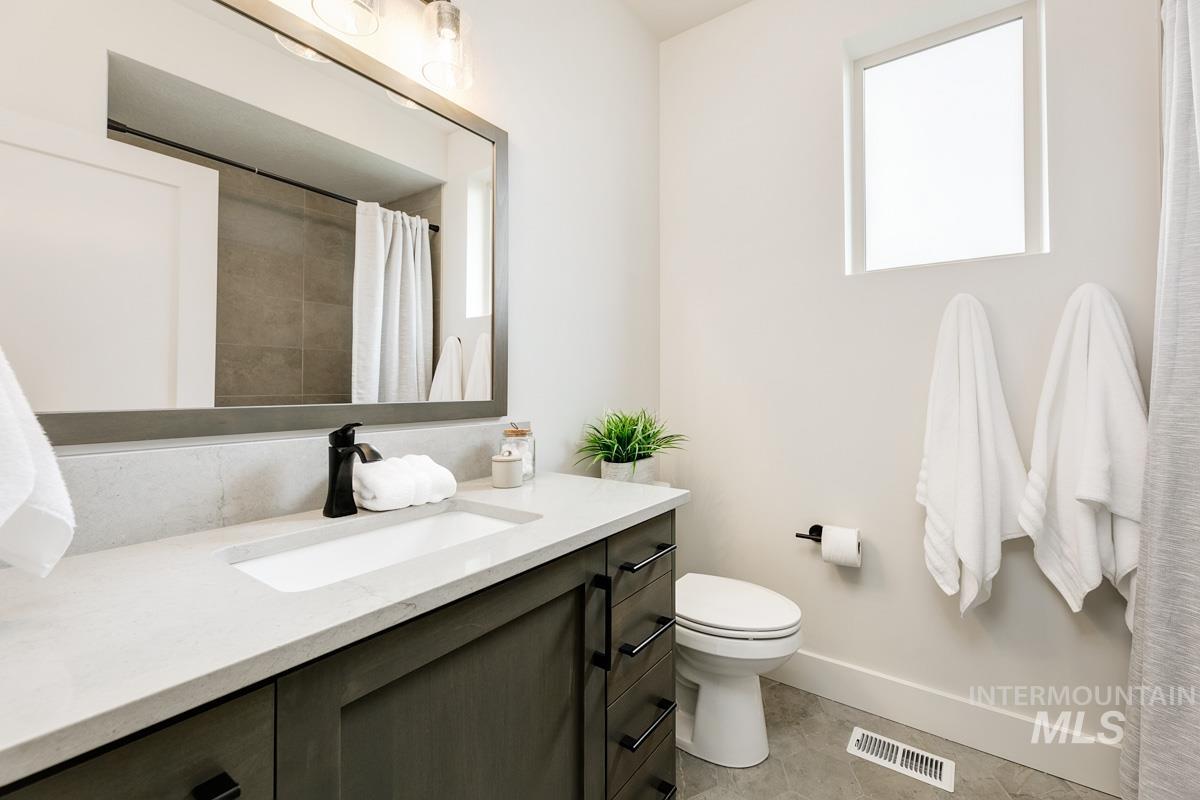 Bathroom featuring vanity, a shower with shower curtain, and light tile patterned floors