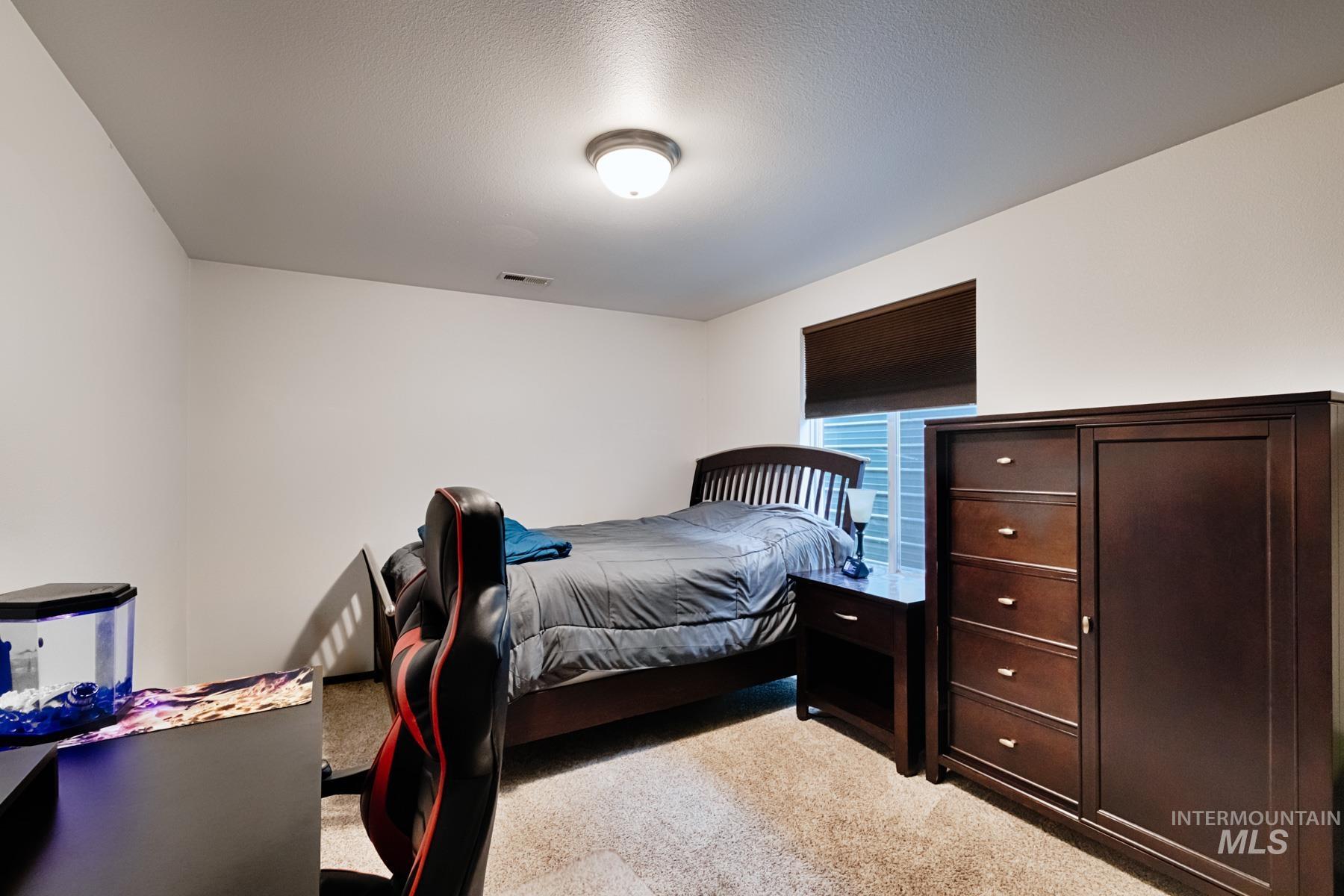 Bedroom featuring light carpet