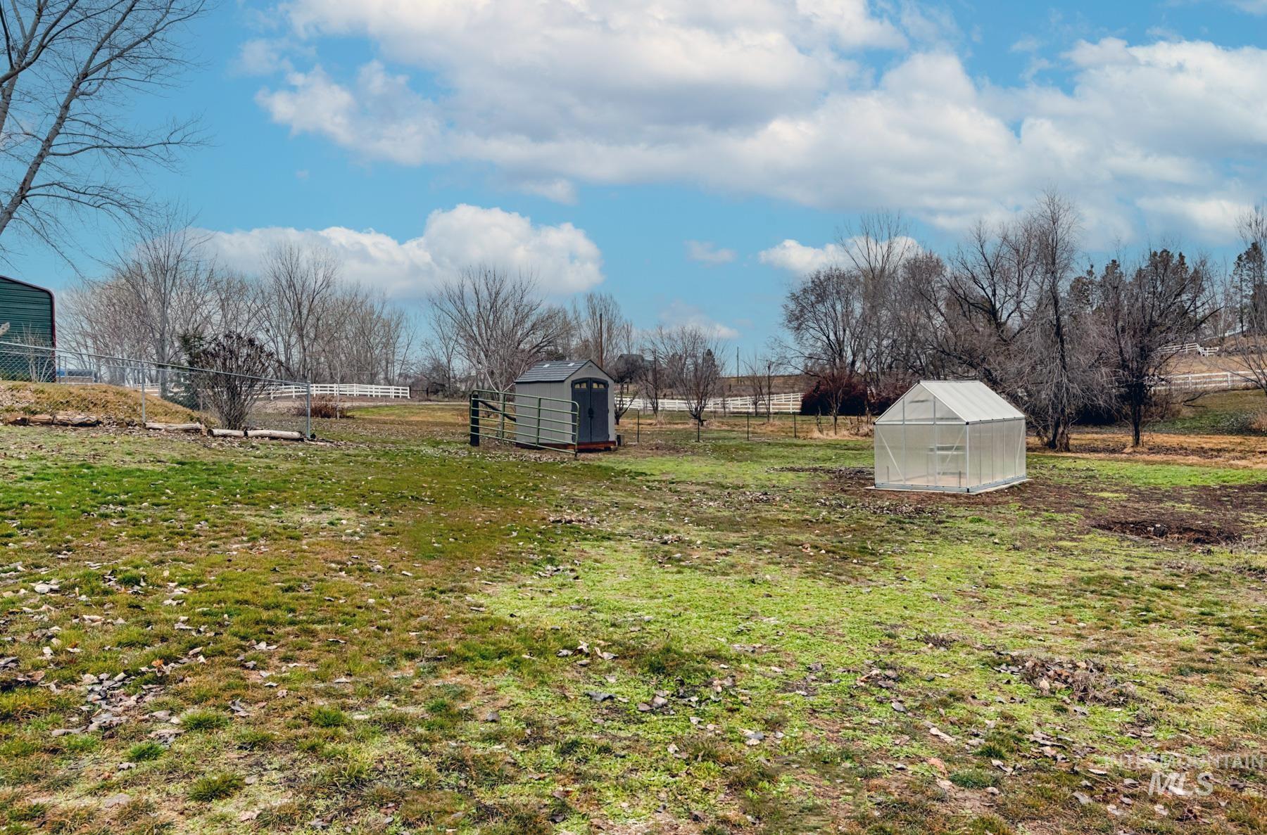 View of yard featuring a storage unit, an exterior structure, and a view of rural / pastoral area