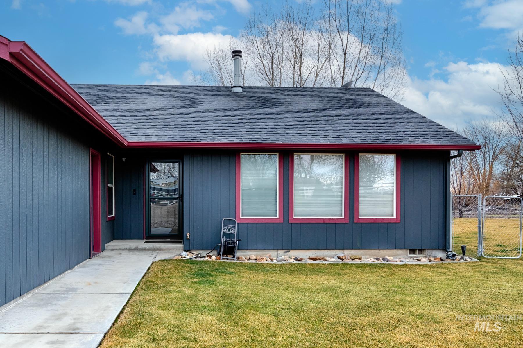 View of exterior entry with roof with shingles and a gate