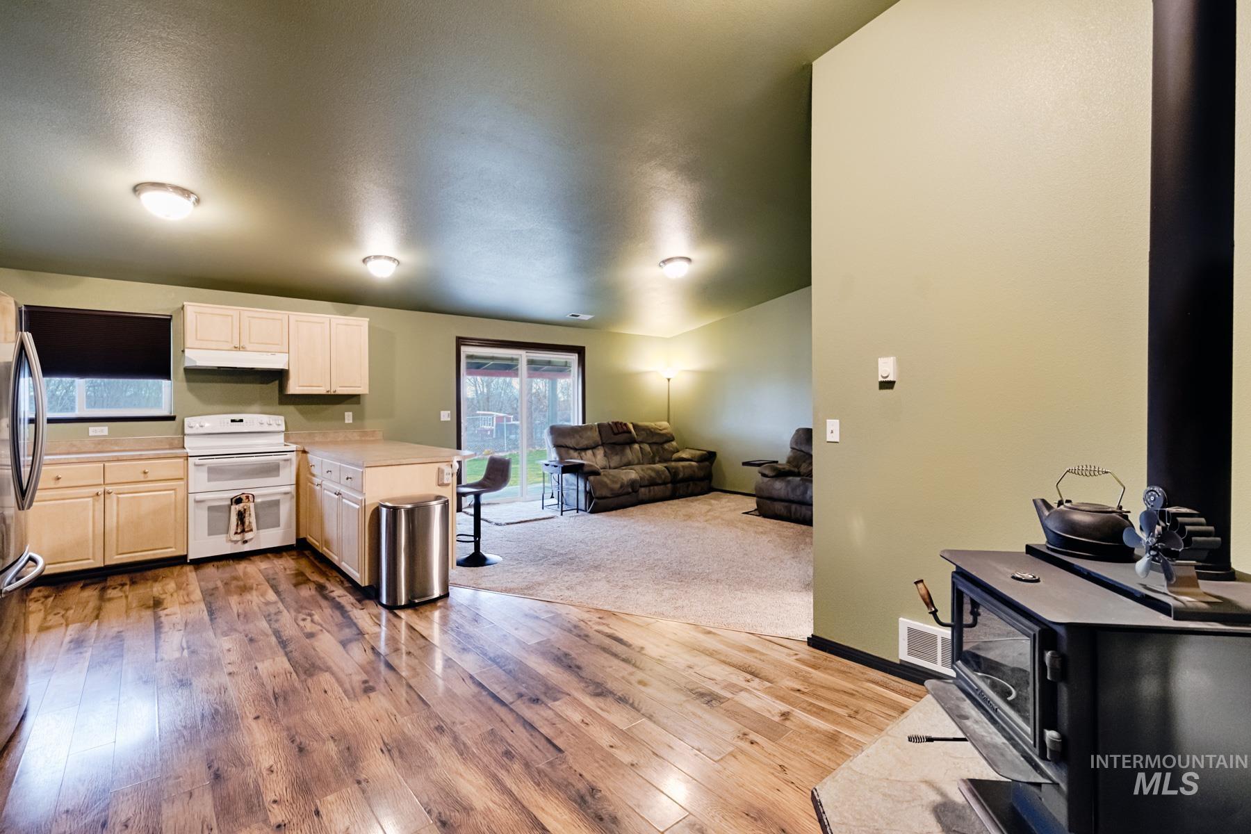 Kitchen with open floor plan, light countertops, range with two ovens, a peninsula, and light wood-type flooring