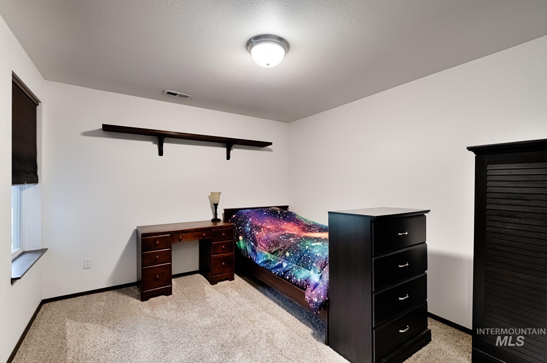 Bedroom featuring light colored carpet