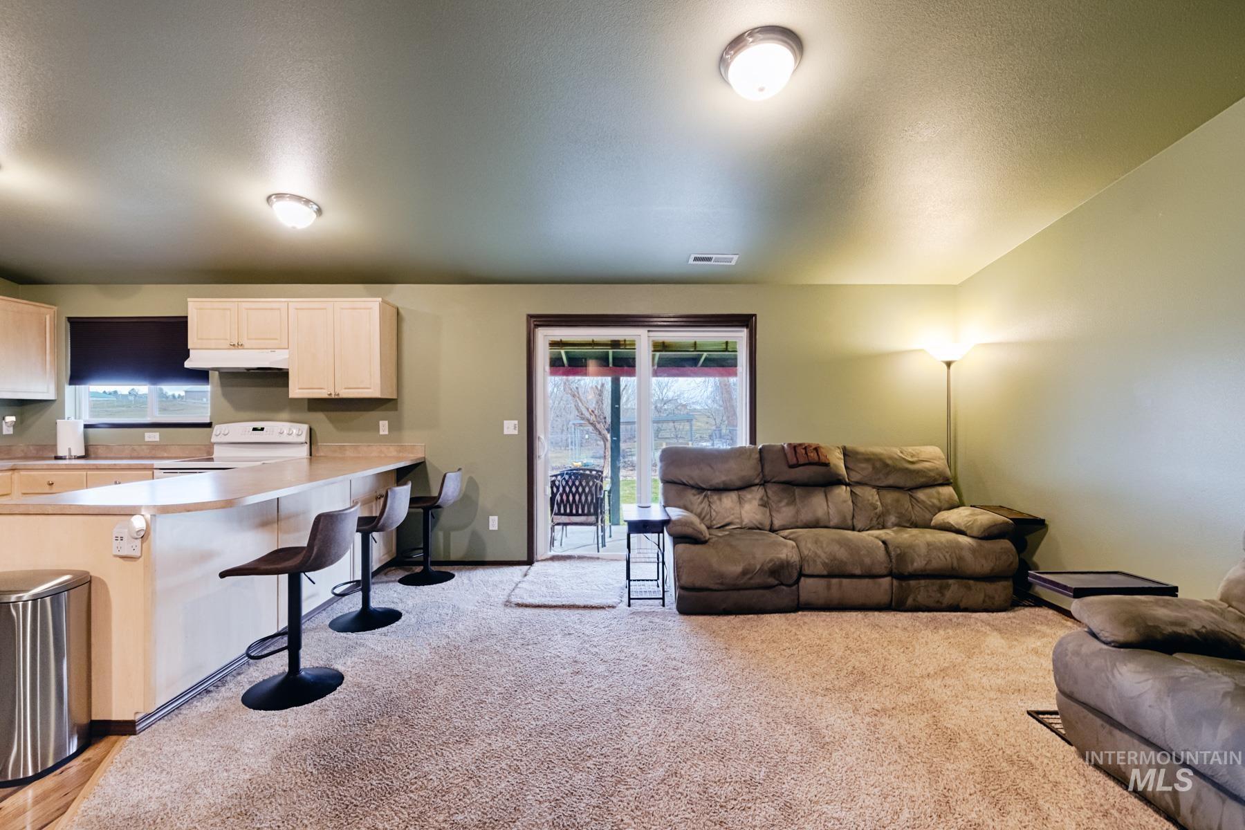 Living area with light colored carpet and a textured ceiling