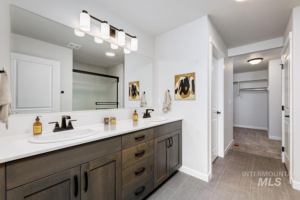 Double vanity with white solid surface countertop and matte black fixtures