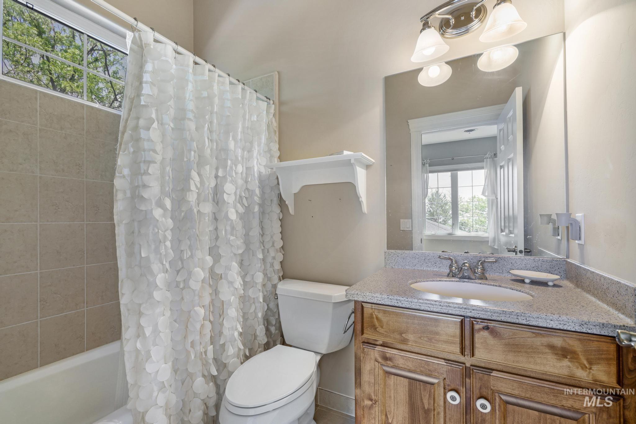 Bathroom featuring shower / bath combination with curtain and vanity
