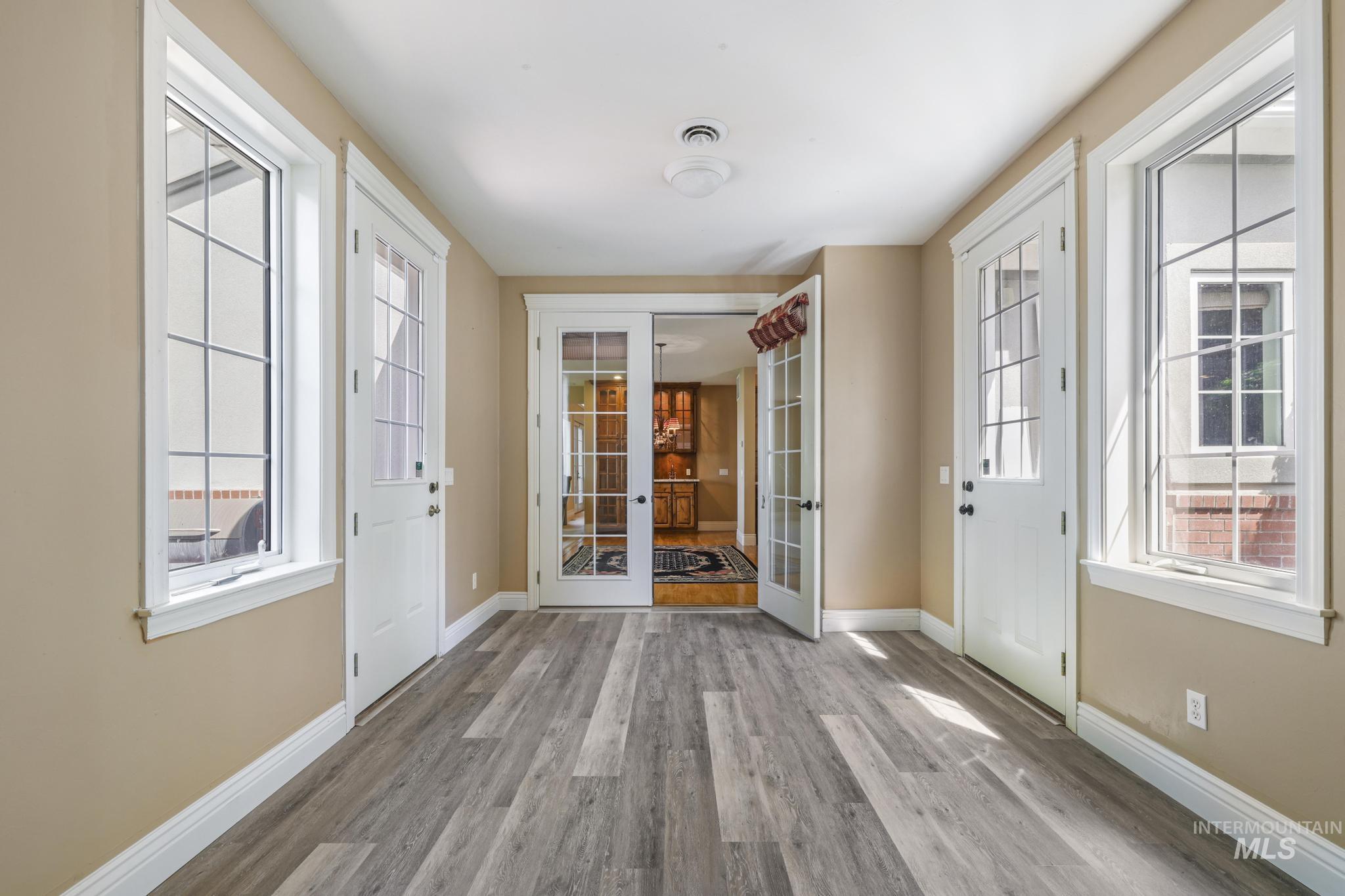 Foyer entrance with french doors and light wood-type flooring