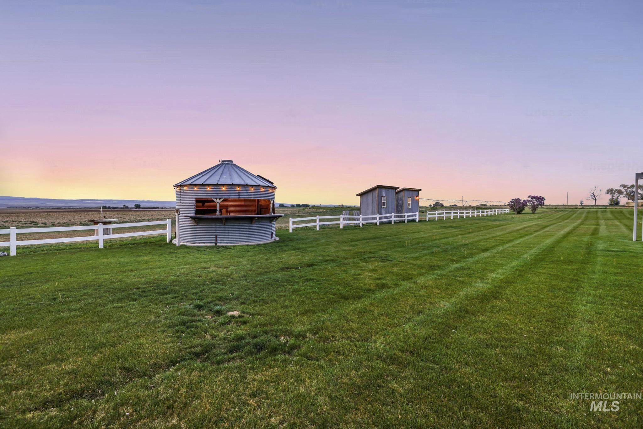 Yard at dusk featuring a gazebo, an outbuilding, and a view of rural / pastoral area