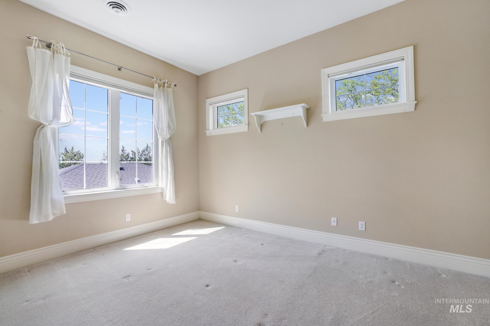 Carpeted spare room featuring baseboards