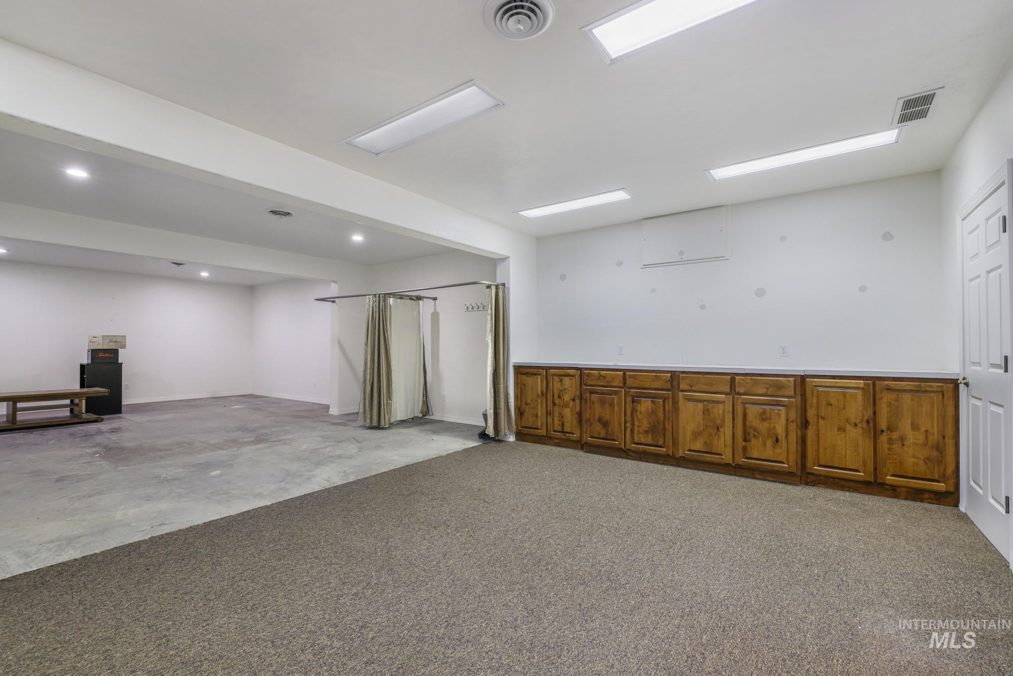 Basement featuring light carpet and baseboards