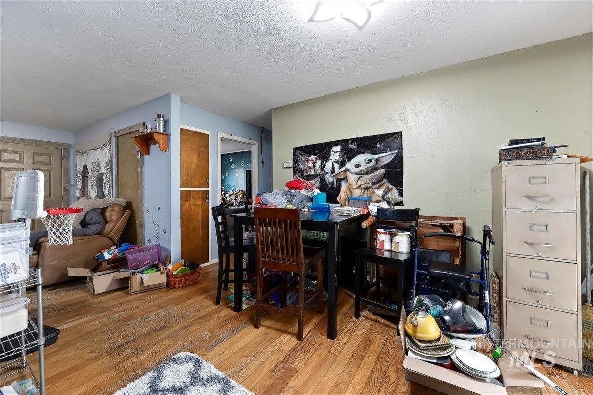 Dining area with light wood-style flooring and a textured ceiling