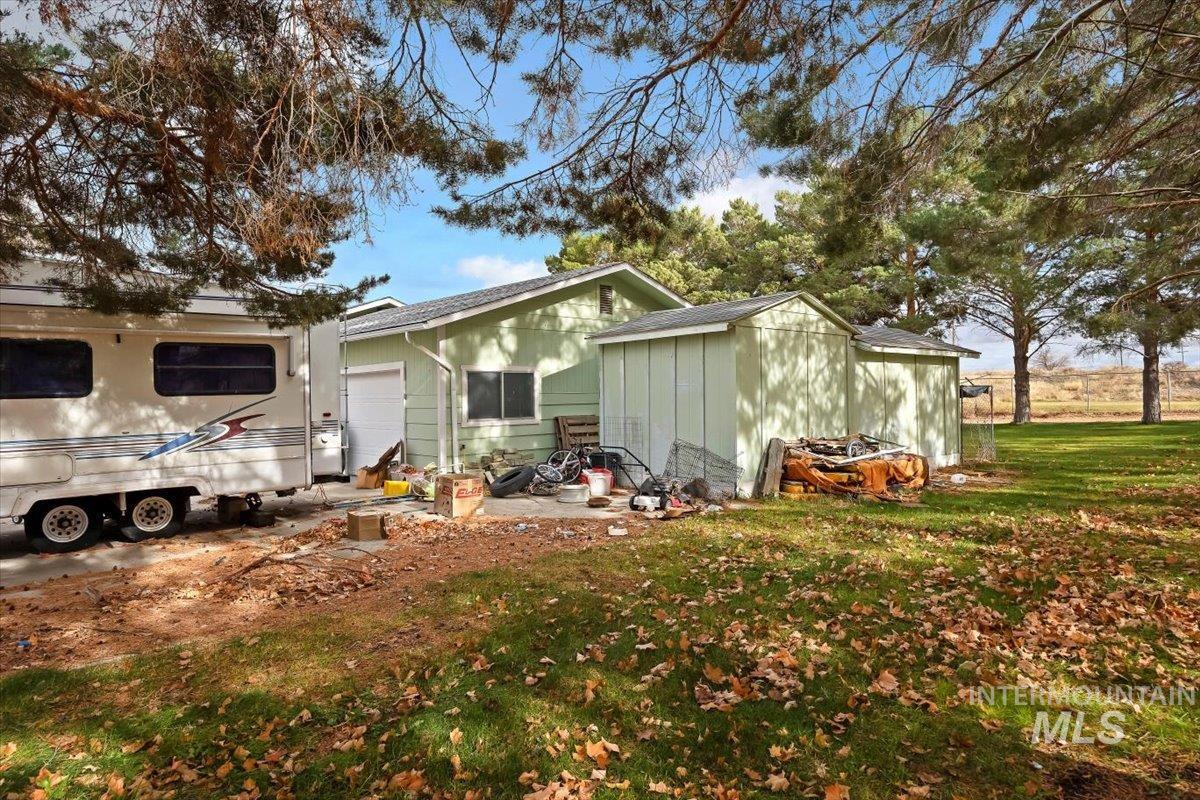 View of front of house with a front lawn, a garage, and a storage unit