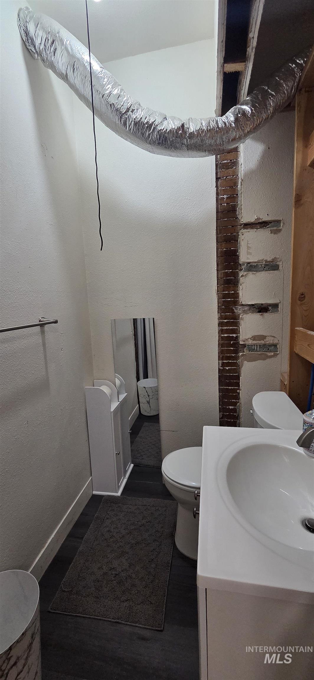 Half bath with vanity and wood finished floors