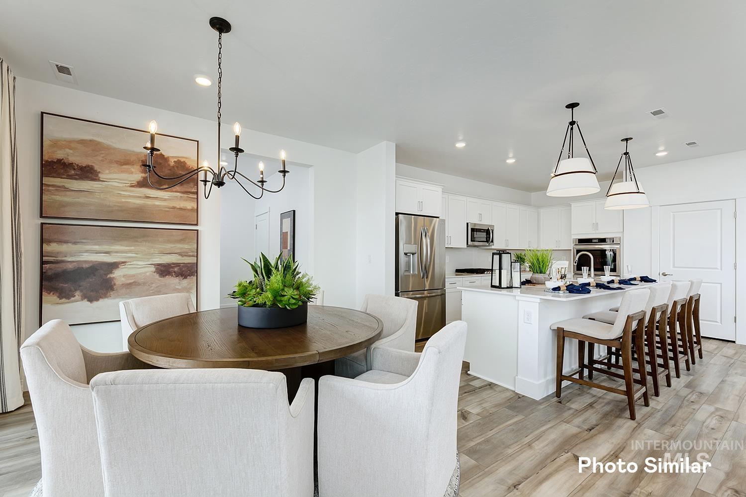 Dining room with light wood-style floors, recessed lighting, and a chandelier