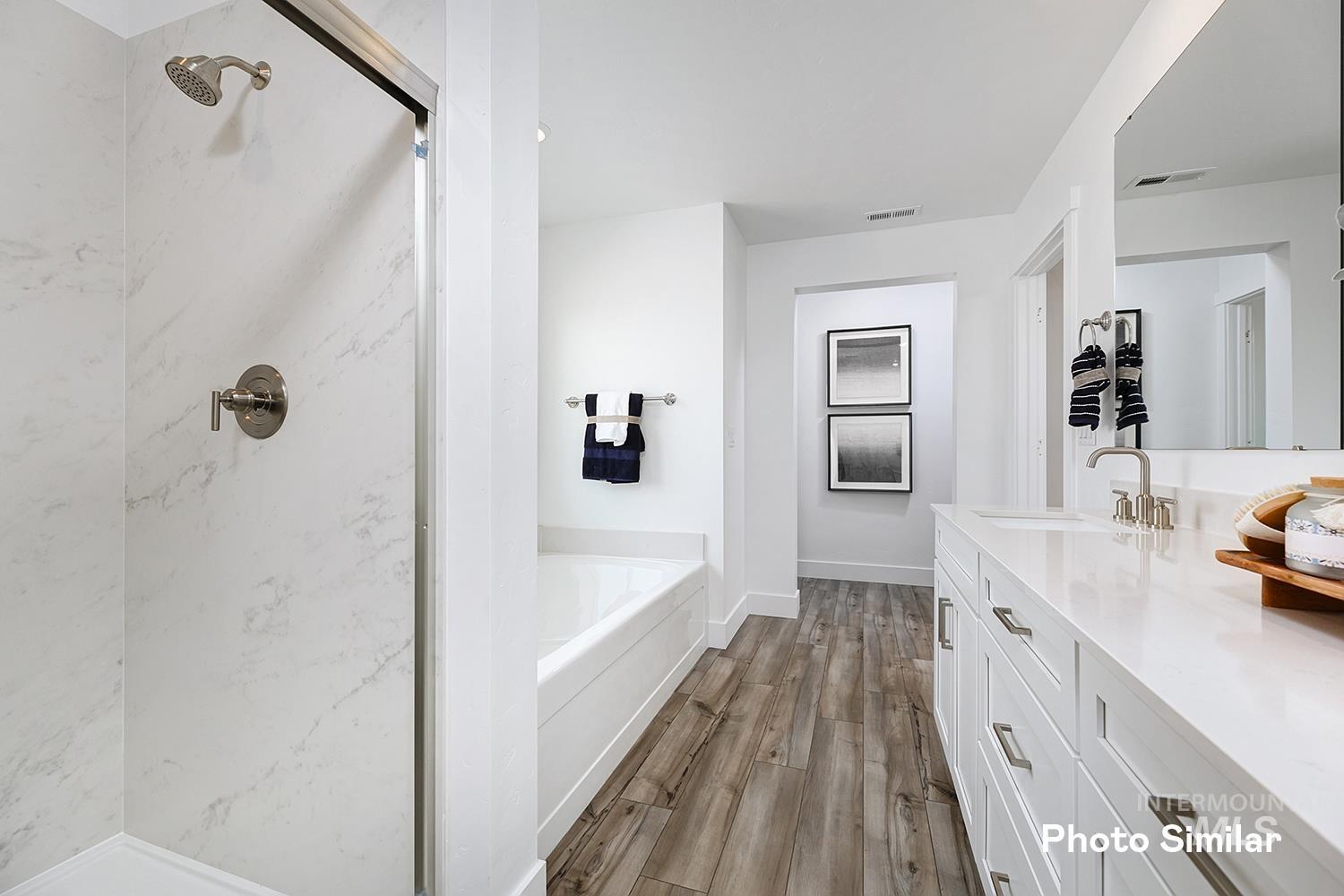 Full bath featuring vanity, a marble finish shower, a garden tub, and dark wood-style floors