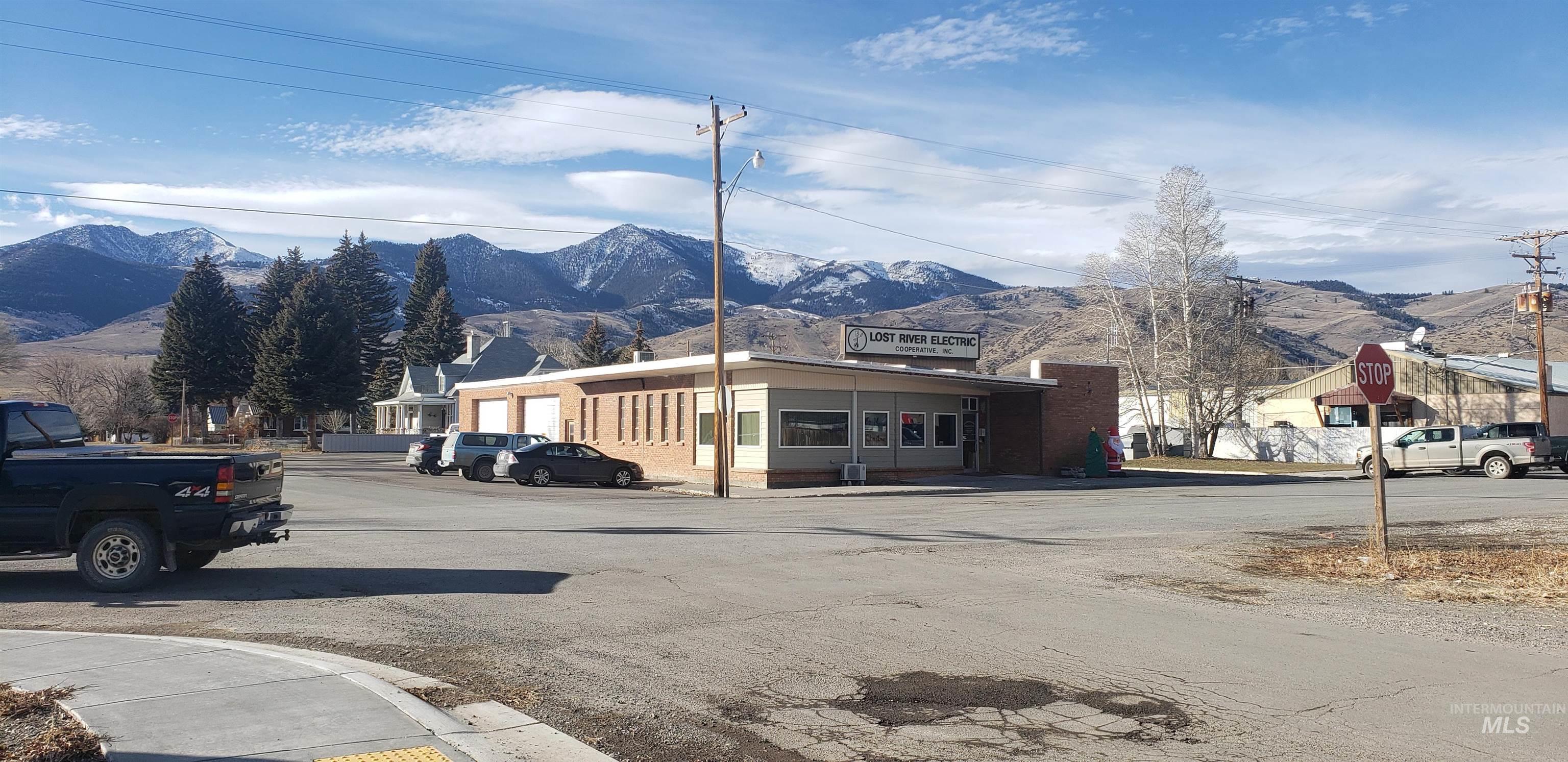View of asphalt street featuring a mountain view, traffic signs, and sidewalks