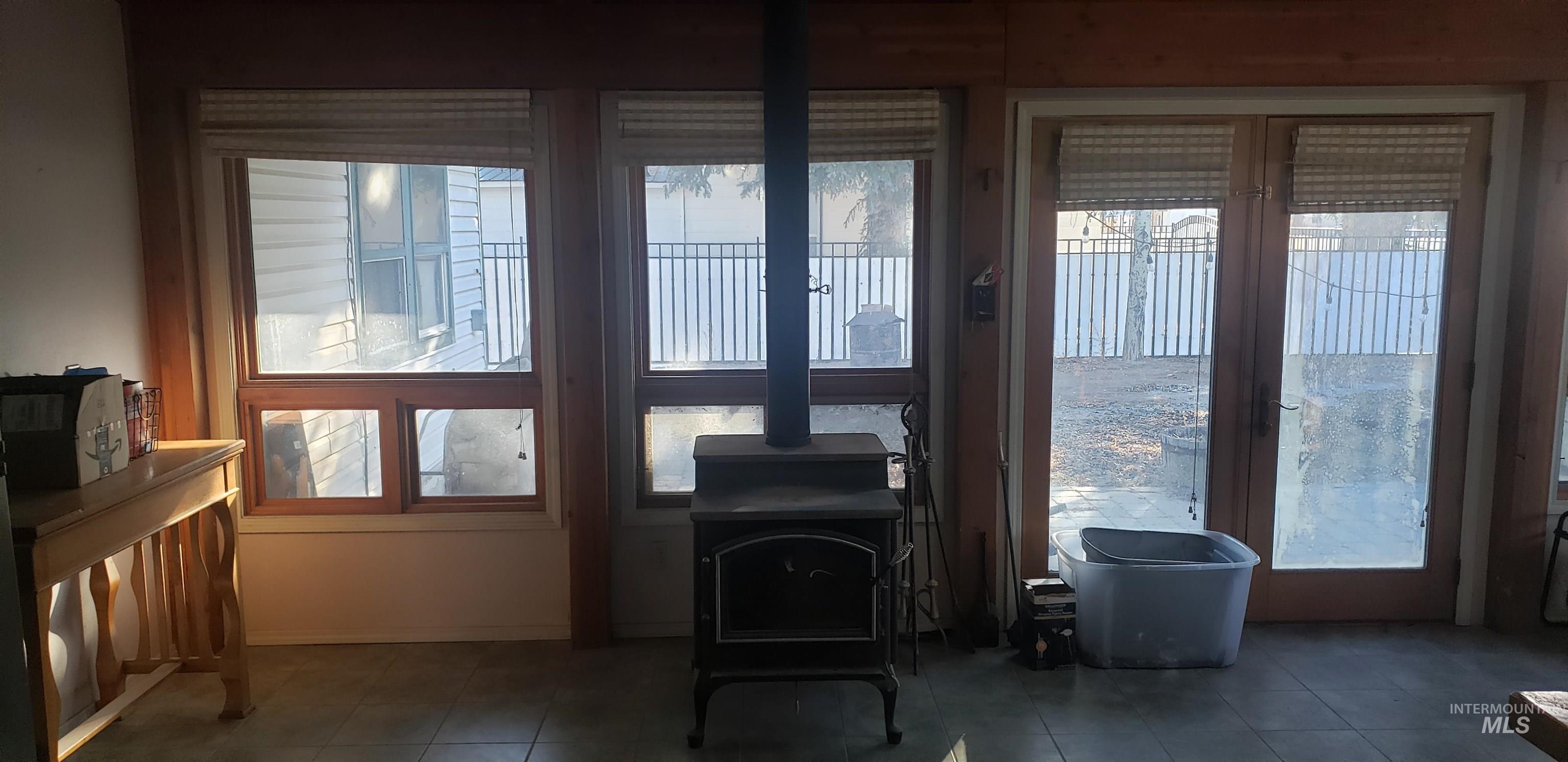 Sunroom with a wood stove, healthy amount of natural light, and french doors