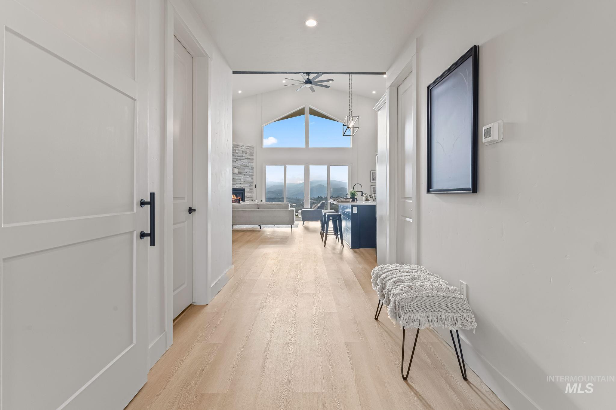 Hall with lofted ceiling and light wood-type flooring
