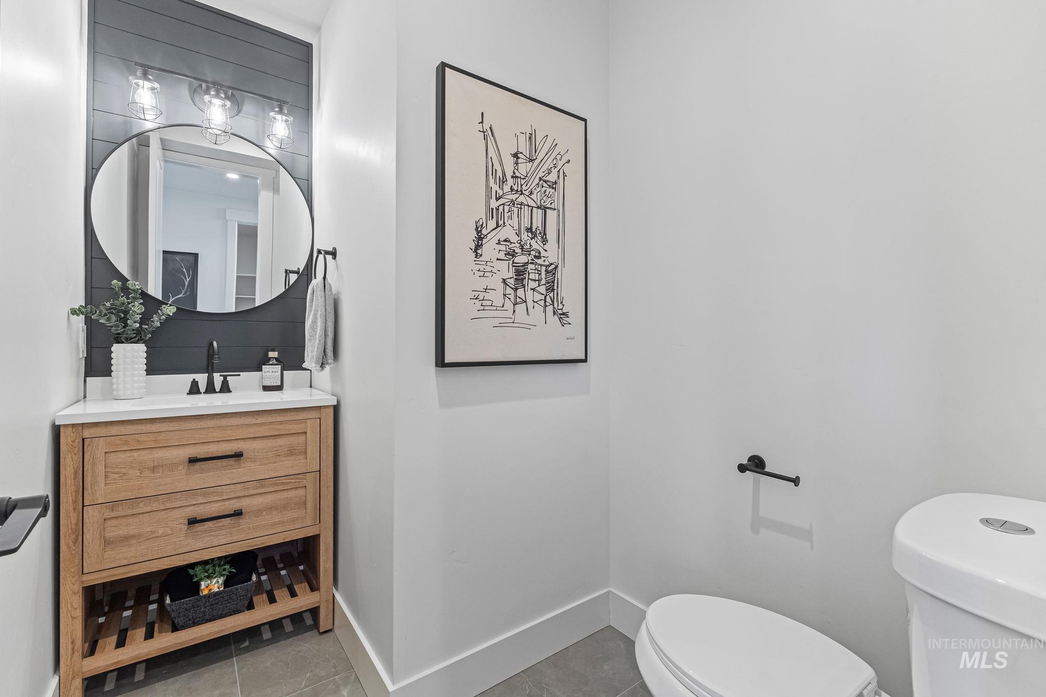 Half bathroom featuring vanity and light tile patterned flooring