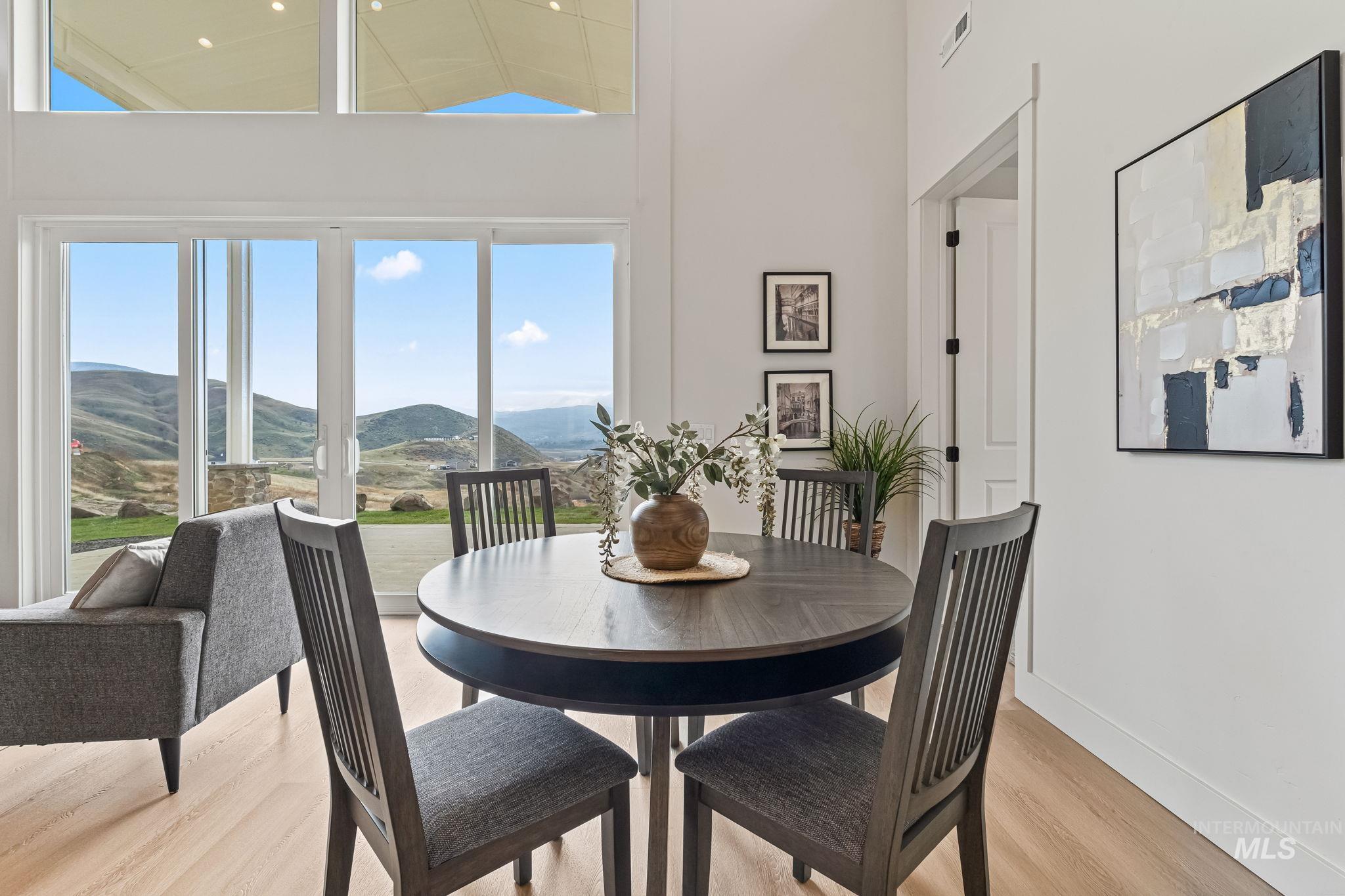 Dining space featuring a mountain view, wood finished floors, and high vaulted ceiling