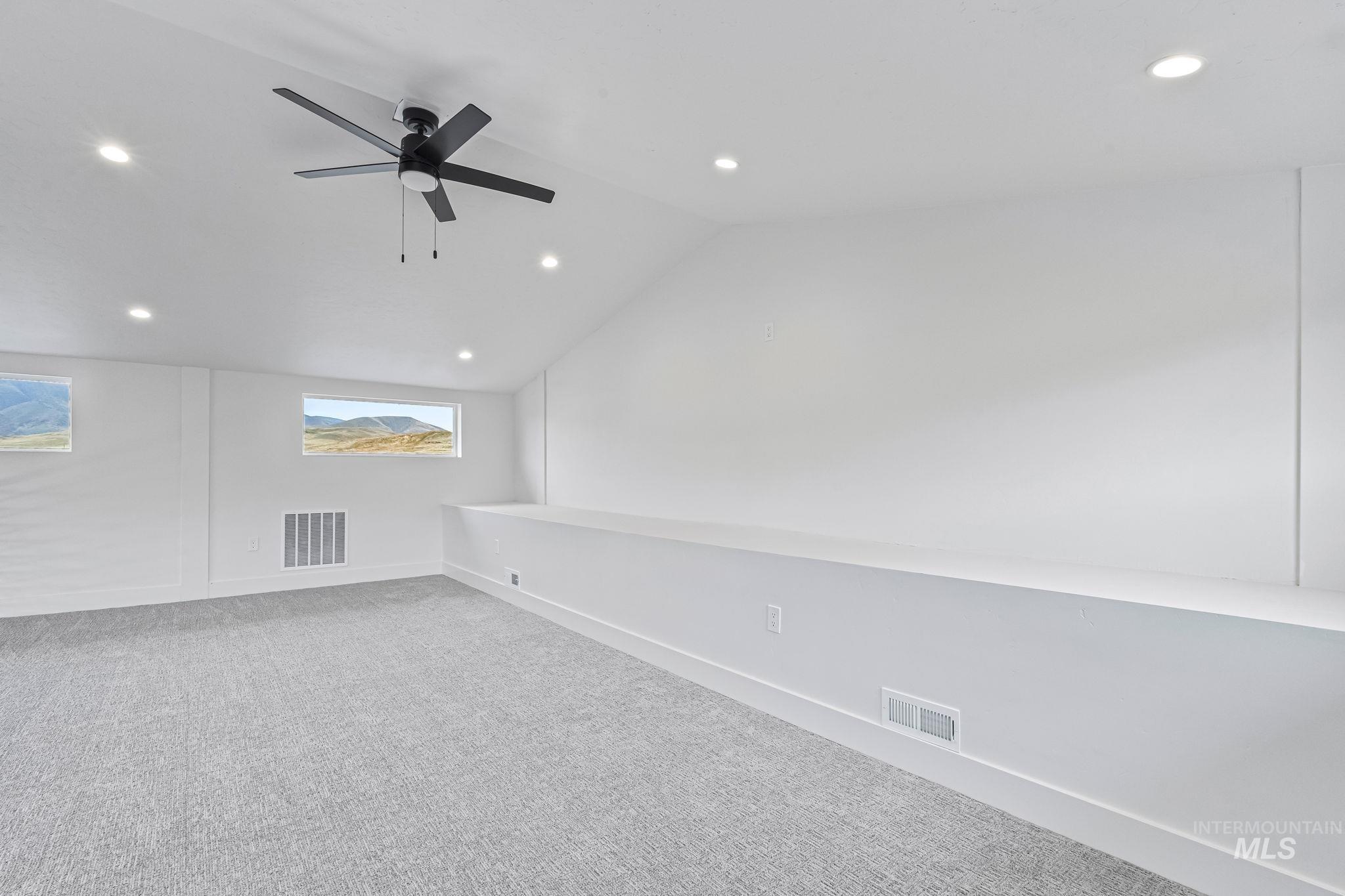 Spare flex room with vaulted ceiling, carpet flooring, recessed lighting, and a ceiling fan
