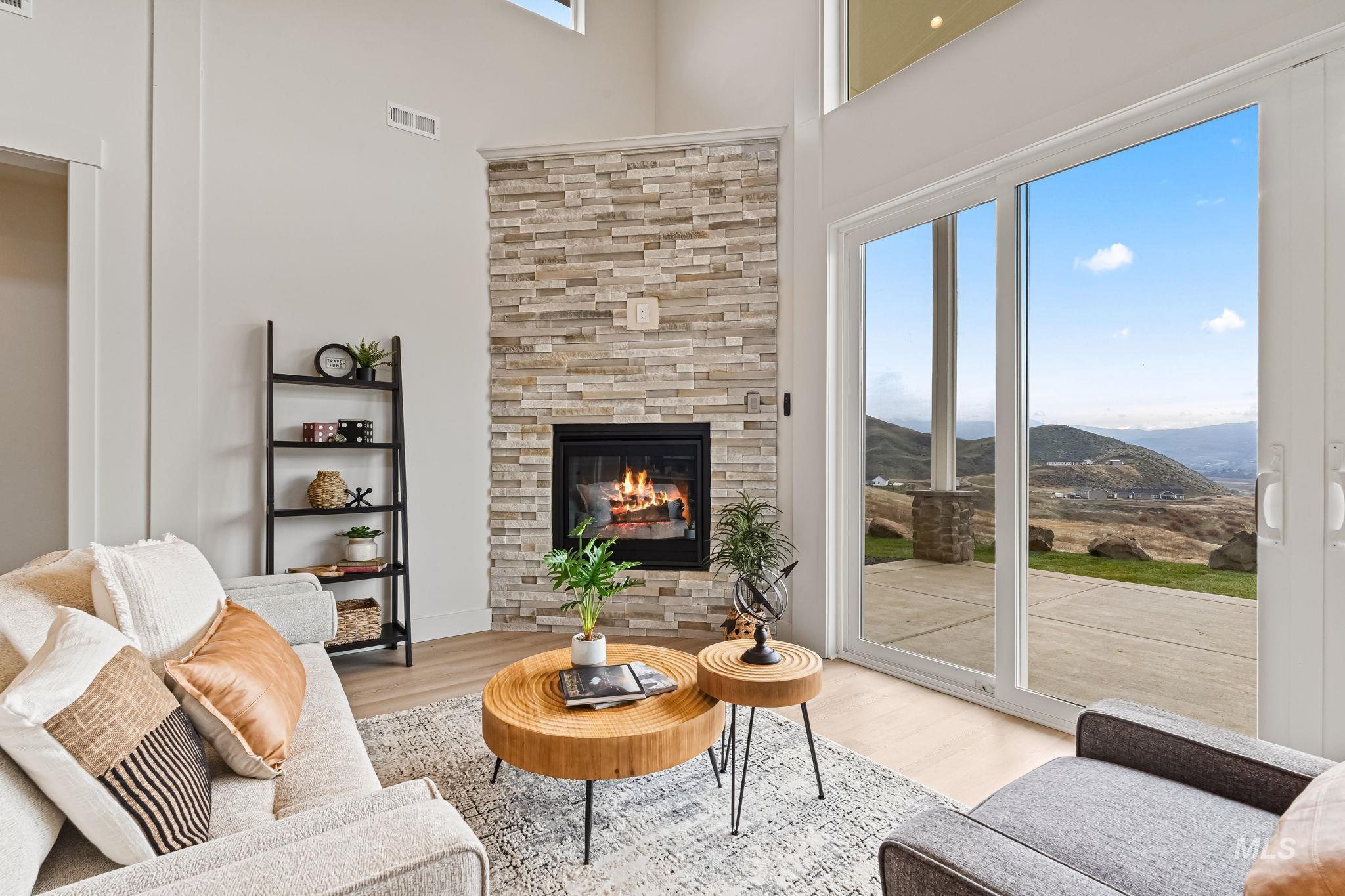 Living room featuring a fireplace, wood finished floors, a mountain view, and a towering ceiling