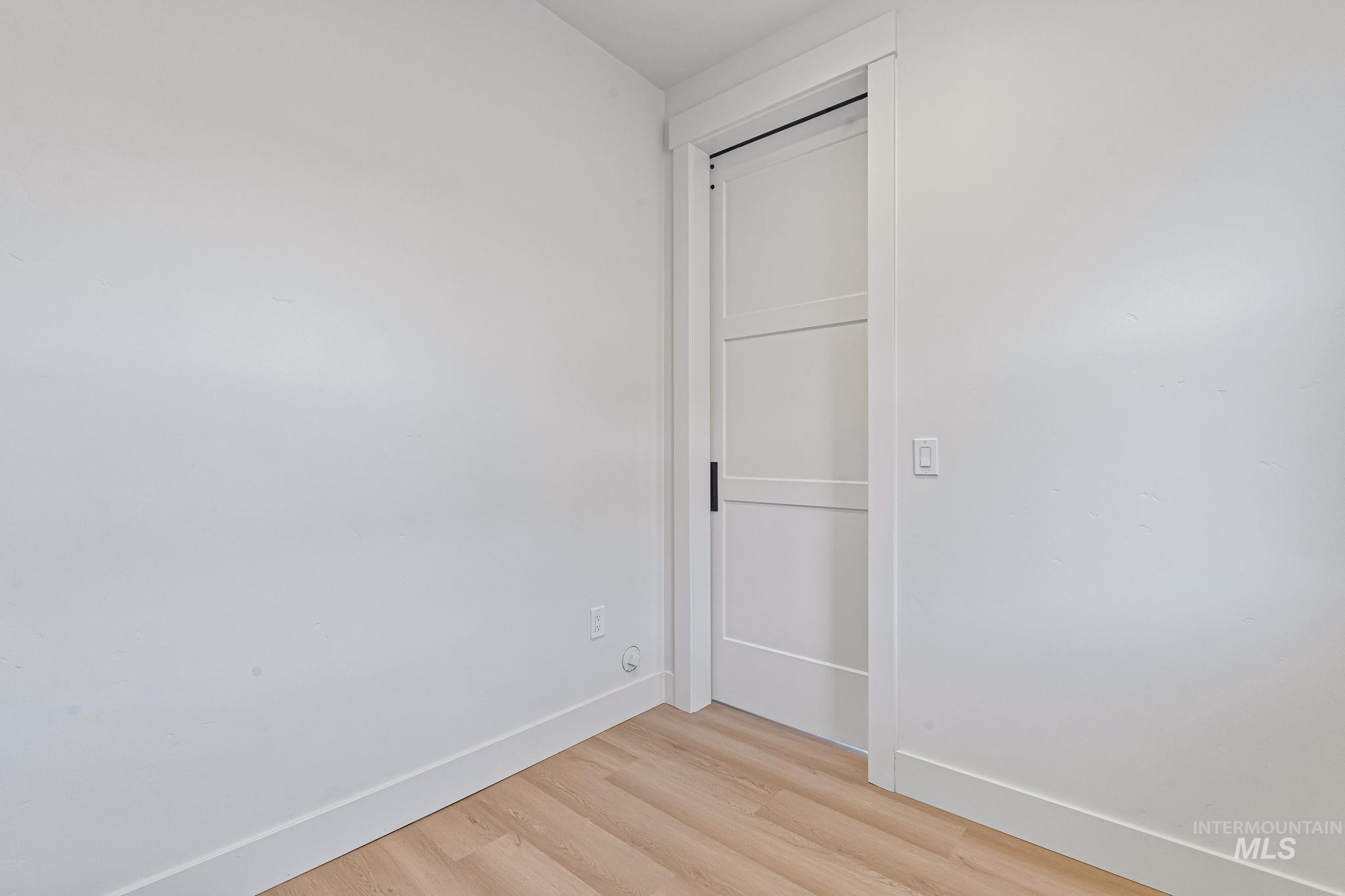 Unfurnished room featuring light wood-type flooring and baseboards