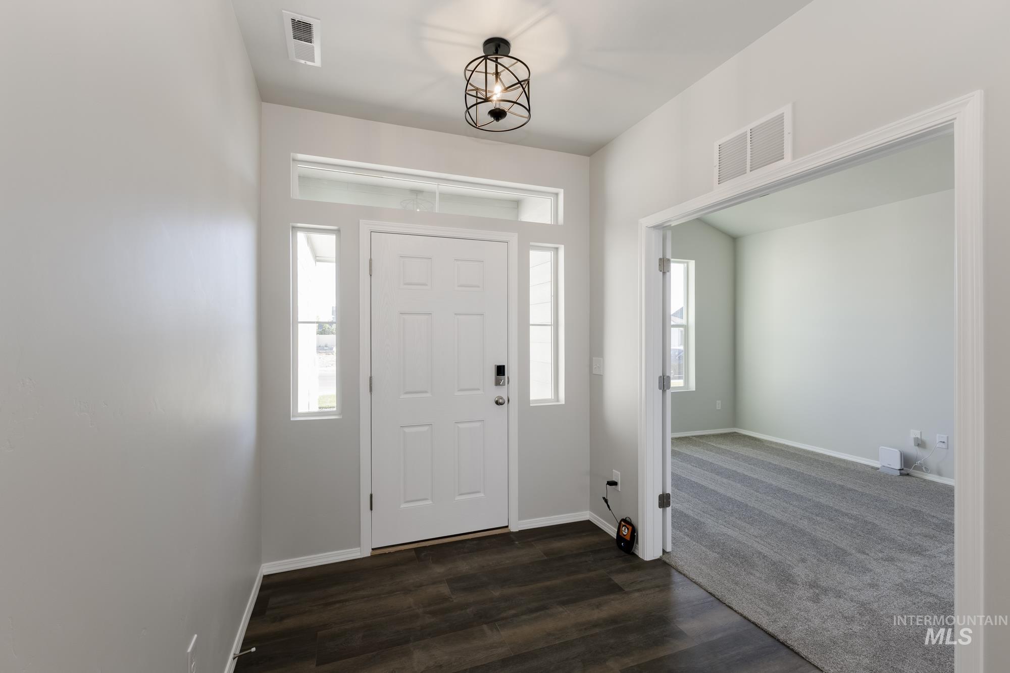 Entryway featuring dark wood finished floors and baseboards