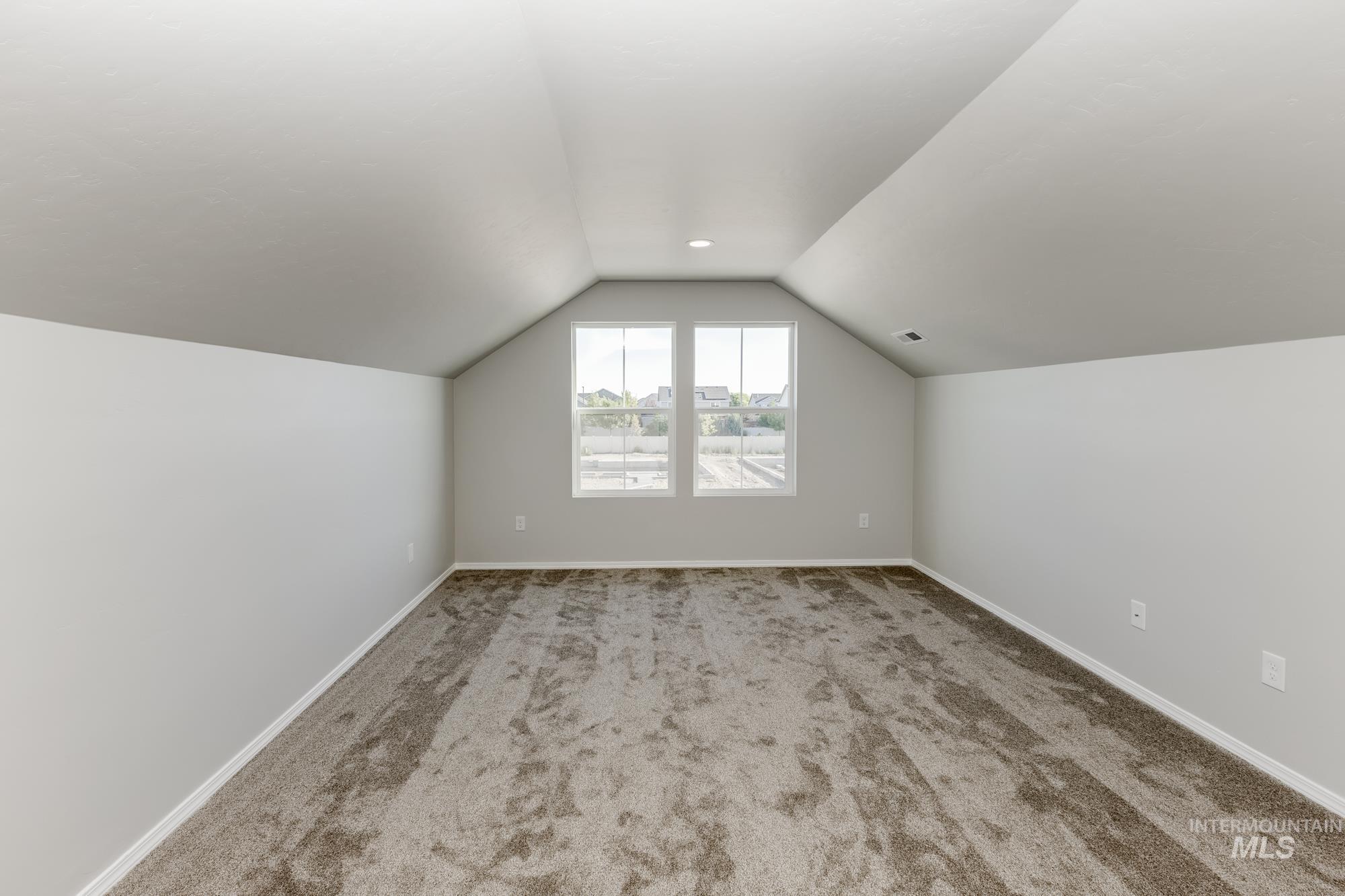 Bonus room featuring lofted ceiling and carpet flooring