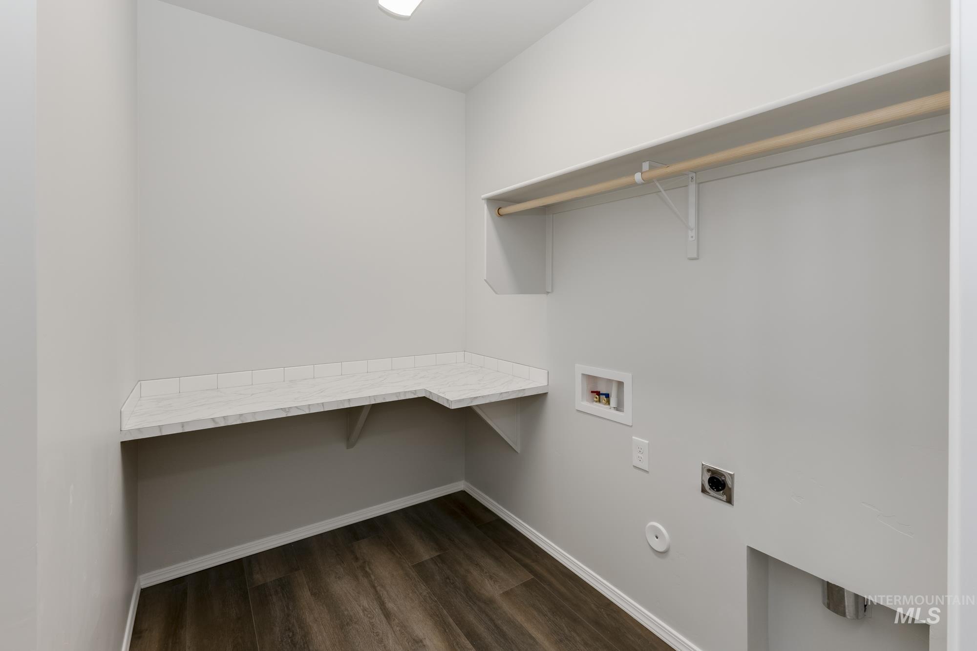 Washroom featuring electric dryer hookup, dark wood-type flooring, washer hookup, a desk, and gas dryer hookup