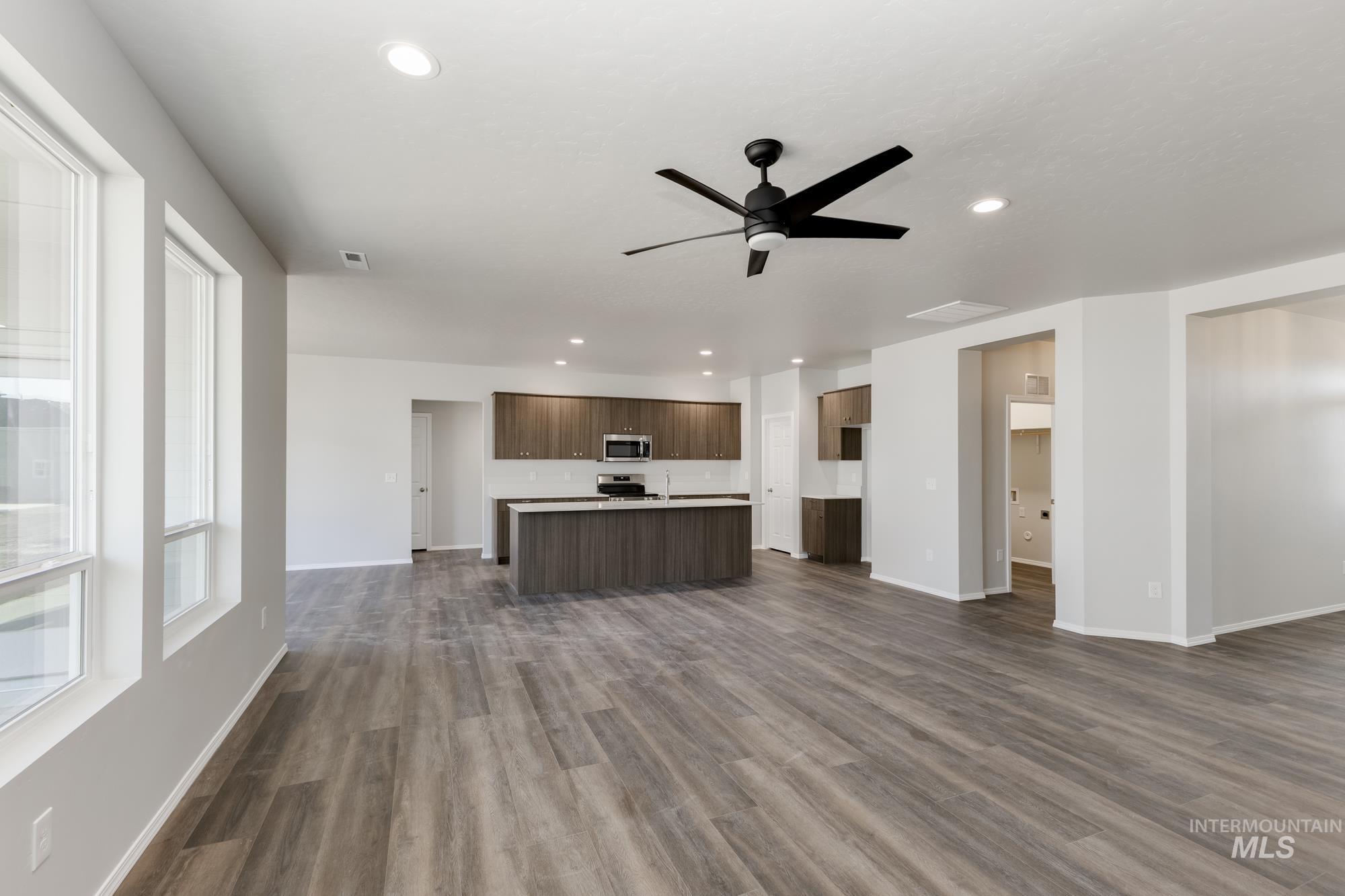 Unfurnished living room with dark wood finished floors, recessed lighting, and ceiling fan