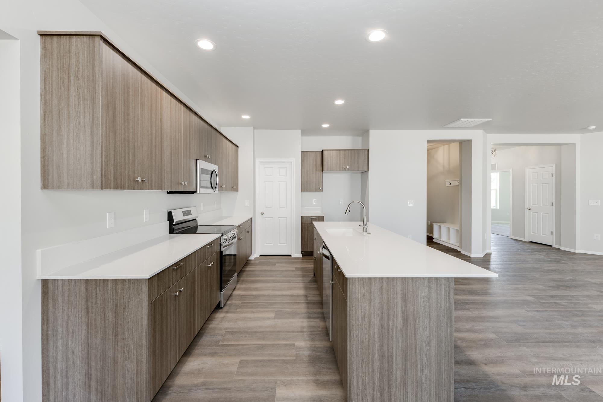 Kitchen featuring stainless steel appliances, modern cabinets, light wood finished floors, light countertops, and recessed lighting