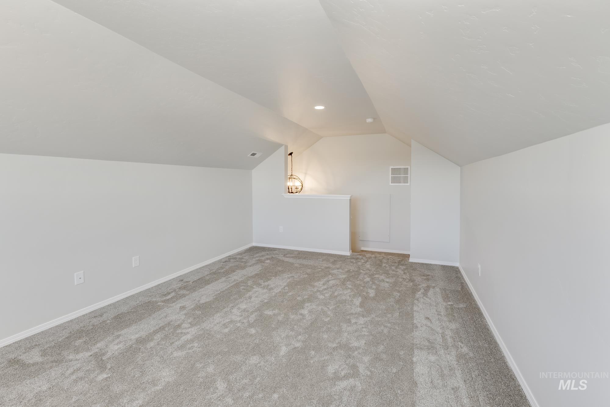 Additional living space with lofted ceiling and carpet floors