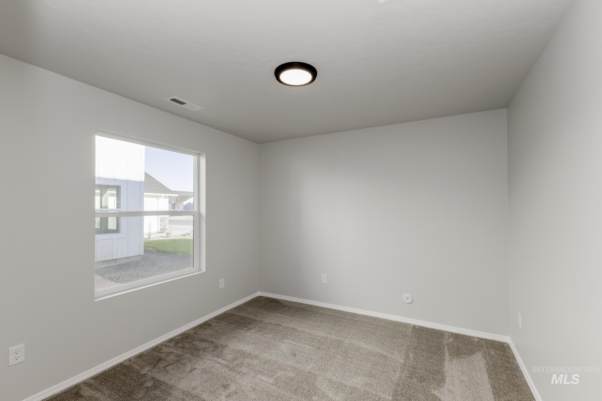 Carpeted spare room with baseboards