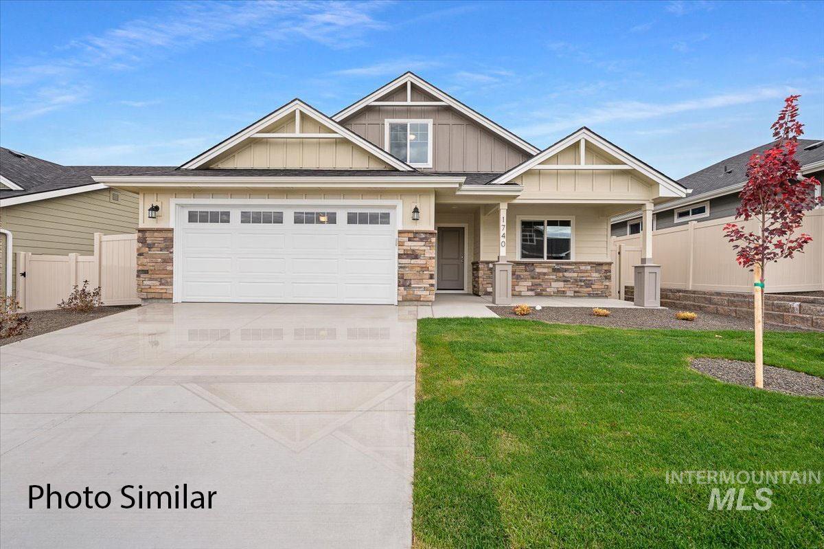 Craftsman-style exterior featuring a multi-gabled roofline, stone veneer accents, a covered entry, and a two-car garage with transom windows