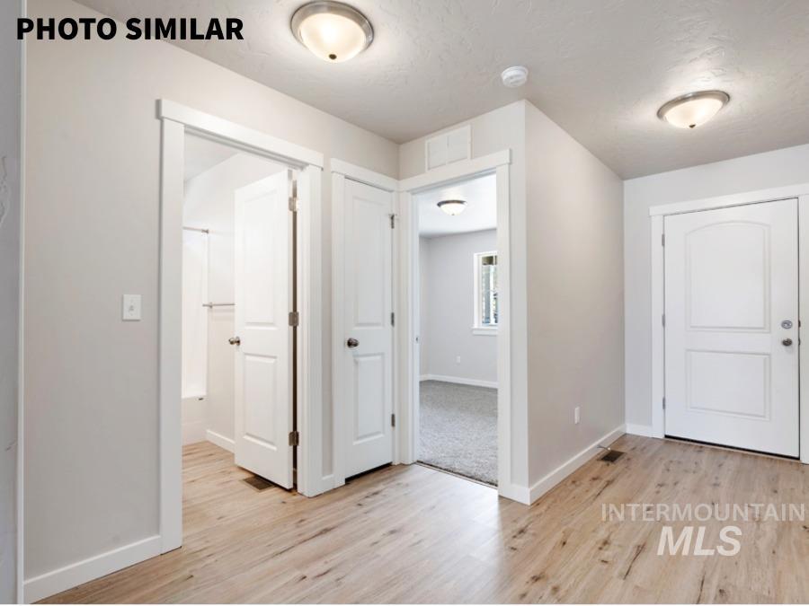 Entryway featuring wood-finish flooring, neutral wall tones, and overhead flush mount lighting